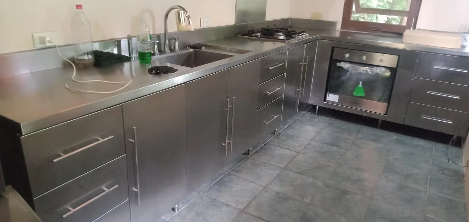 An EVA custom stainless steel kitchen with fitted counters, sink and cabinets